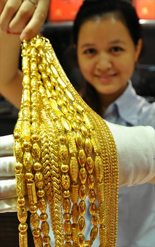 A saleswoman displays gold necklaces at a store in Handan, Hebei Province. As the US government shutdown drags into a second week, the spot gold price rose 0.4 percent to $1,325.96 per ounce by 0250 Greenwich Mean Time Tuesday, trading near its highest point in a week, Reuters reported. Photo: CFP