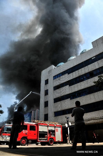 Smokes rise from a burning four-story commercial building in Liuzhou, south China's Guangxi Zhuang Autonomous Region, July 1, 2013. Twelve fire trucks and 49 firefighters have been dispatched to fight the blaze. No casualties have been reported thus far. (Xinhua) 