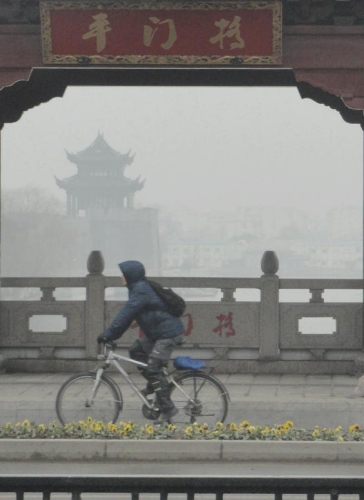 A man rides on a fog-shrouded bridge in Suzhou City, east China's Jiangsu Province, Jan. 22, 2013. (Xinhua/Wang Jiankang) 