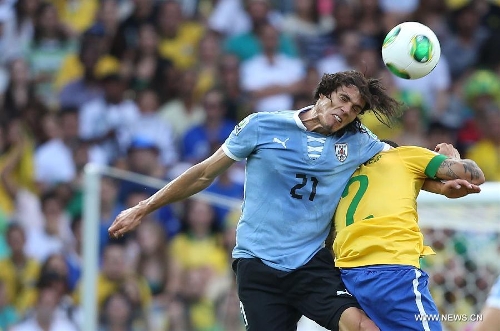 Brazil's Dani Alves (R) vies for the ball with Edinson Cavani (L) of Uruguay, during the FIFA's Confederations Cup Brazil 2013 semifinal match, held at Mineirao Stadium, in Belo Horizonte, Minas Gerais state, Brazil, on June 26, 2013. (Xinhua/Liao Yujie)