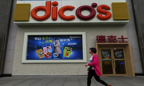 A women passes by a branch of Dico's, a fast-food restaurant in Yichang, Hubei Province on Tuesday. Ting Hsin International Group, the owner of the fast-food chain, said Monday  that as of September it had opened 2,000 Dico's in the Chinese mainland. Photo: IC