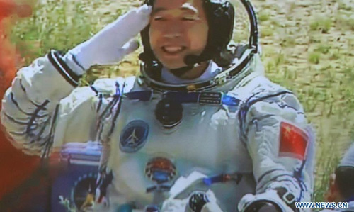 This screen shot taken on June 29, 2012 in the Beijing Aerospace Control Center shows Chinese astronaut Jing Haipeng saluting to crowds after coming out of the re-entry capsule of Shenzhou-9 spacecraft in Siziwang Banner of north China's Inner Mongolia Autonomous Region. Photo: Xinhua