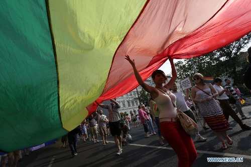 Participants carrying a rainbow flag, symbol of the LGBTQ movement, walk across the city during the Gay Pride Parade in Budapest, Hungary on July 6, 2013. (Xinhua/Attila Volgyi) 