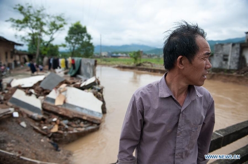  A villager stands beside his house destroyed by the rainstorm in Haoling Village of Jiaoling County, Meizhou City, south China's Guangdong Province, May 22, 2013. Meizhou City was hit by a rainstorm on May 19, which killed one people and destroyed 951 houses, leaving 180, 000 people affected in Jiaoling County. (Xinhua/Mao Siqian) 