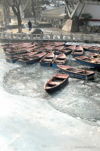 Boats float on icy water at Quancheng Park in Jinan, capital of east China's Shandong Province, Jan. 6, 2013. Influenced by cold front, the temperature of Shandong this winter is colder than the past years. The average temperature of recent 10 days has even hit a 30-year low. (Xinhua/Xu Suhui) 