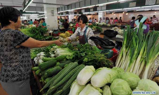 Citizens buy vegetables at a market in Sanya, south China's Hainan Province, July 9, 2012. China's Consumer Price Index (CPI), a main gauge of inflation, grew by 2.2 percent year on year in June, down from 3 percent in May, the National Bureau of Statistics (NBS) said on Monday. Photo: Xinhua