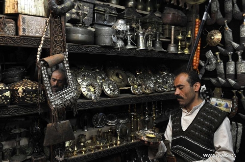 A vendor waits for customers on a street in the Old City of Sanaa, Yemen, on March 24, 2013. According to local media, Yemen's tourism sector suffered losses estimated at one billion U.S. dollars following the 2011 crisis. Vendors in the Old City of Sanaa, a UNESCO World Heritage Site, said the number of foreign tourists declined by at least 90 percent due to the 2011 unrest that severely undermines security in Yemen. (Xinhua/Mohammed Mohammed) 