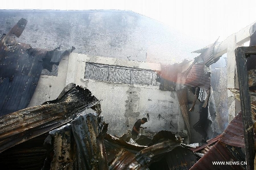 A man looks for reuseable materials at his charred home after a fire hit a residential area in Valenzuela City, the Philippines, Feb. 19, 2013. Around 500 houses were razed in the fire, leaving 2,000 residents homeless. (Xinhua/Rouelle Umali) 