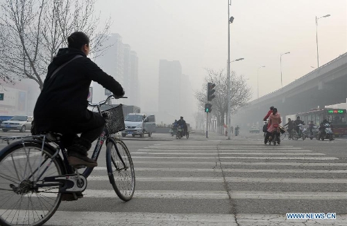 People travel amid heavy fog in Shijiazhuang, capital of north China's Hebei Province, Feb. 27, 2013. The province was hit by heavy fog on Feb. 27 morning, making several cities in the province suffer from heavy air pollution. (Xinhua/Zhu Xudong)