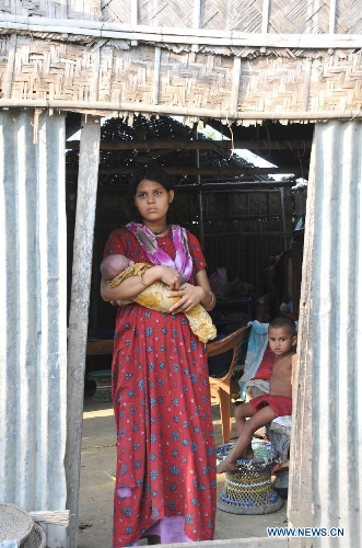 A woman stands in her shelter after a tornado swept through the Brahmanbaria district, some 109 km east of the capital Dhaka, Bangladesh, March 23, 2013. The death toll caused by a devastating tornado in eastern Bangladesh rose to 20 on Saturday, a local TV channel reported. (Xinhua/Shariful Islam)