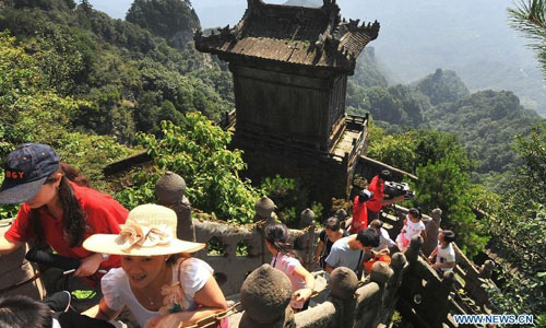 Visitors climb up the Wudang Mountain in central China's Hubei Province July 11, 2012. As the cradle of the Taoist culture, the Wudang Mountain was inscribed on the list of World Cultural Heritages in 1994. The scenery of the mountain attracts tens of thousands of visitors every year. Over 4 million tourists from at home and abroad are expected to visit the site this year. Photo: Xinhua