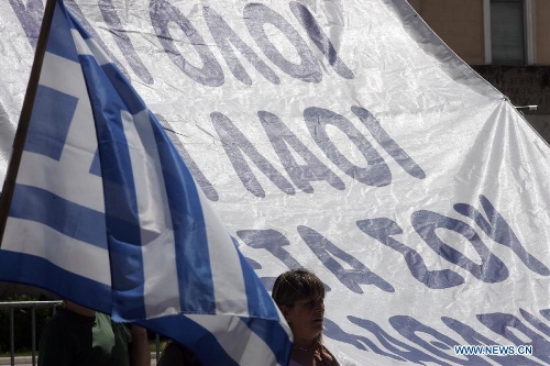 A woman takes part in a protest in front of the House of Parliament, in Athens, Greece, May 1, 2013. Greece is in the grip of a new 24-hour general strike on Wednesday, as the country's largest unions of public and private sector workers ADEDY and GSEE mark Labor Day with anti-austerity rallies in central Athens and other major cities. (Xinhua/Marios Lolos) 