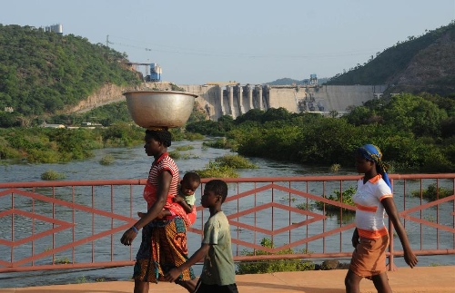 Ghanaians pass by the Bui dam, Ghana, on May 3, 2013. The first power generating unit of 133 megawatts from the Bui hydroelectric project was officially started on May 3, 2013. The project, which is being constructed by China's Sinohydro Corporation, will generate 400 megawatts of power when it becomes fully operational by the end of 2013. Started in April 2008, the project was financed by the governments of Ghana and China at a total cost of nearly 800 million U.S. dollars, with the Chinese government providing 90 per cent of the funds while its Ghanaian counterpart paid ten percent.(Xinhua/Shao Haijun) 