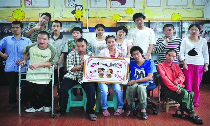 Qiu Jian, 24, from a welfare house in Fuzhou, takes a photo with other residents, carrying a handicraft made by others as a wedding gift. Photo: CFP