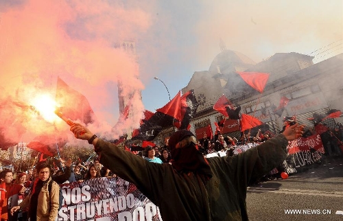 A group of people participates in a protest called by the Worker's United Center (CUT, by its Spanish acronym), The School of Teachers, and social organizations, in Valparaiso, Chile, on May 21, 2013. The protest was performed simultaneously with the delivery of the last management report by president Sebastian Pinera before Chile's National Congress. (Xinhua/Jorge Villegas) 