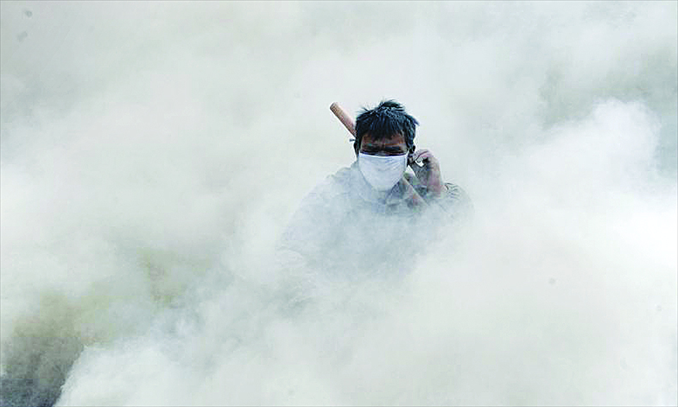 Dust swirls around a man after a forklift passes by in Xinjiang. Photo: CFP