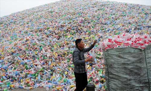 A worker collects plastic bottles at a landfill in Hangzhou, East China's Zhejiang Province on Thursday. The landfill occupies an area of 2,667 square meters. Photo: CFP