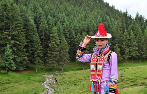 A tour guide of the Yugur ethnic group shows her costume in the Yugur Autonomous County of Sunan, Northwest China's Gansu Province, July 23, 2012. Gansu's Sunan County has become a populous tourists site in recent years, boasting its diversified scenic view, including snow mountains, grasslands, valleys, deserts and lakes. Photo: Xinhua