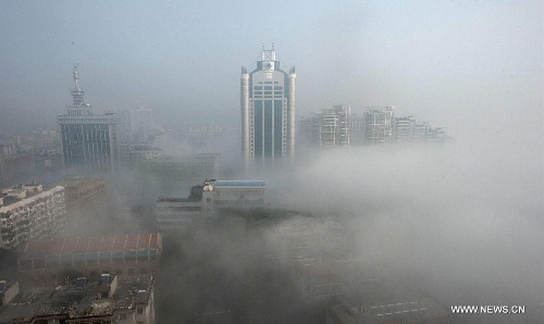 Buildings are seen amid dense fog in Wuhan City, capital of central China's Hubei Province, Jan. 12, 2013. (Xinhua/Cheng Min)  