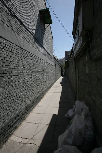 A narrow Hutong(Photo: CRIENGLISH.com/ Wang Zhi)A Hutong is a traditional alley, characteristic of an old Beijing city. A total of 7000 Hutongs have been built throughout the capital in straight lines under strict construction guildlines. The longest Hutong starts from the Beijing Legation Quarter, Dong Jiao Min Xiang,to the Xijiao Min Xiang, and has a total length of 6.5 kilometers, while the shortest Hutong is One-inch Street at only several meters' long. The narrowest Hutong is only about 0.7 meters wide. Therefore, people carrying even a little bit of extra weight have to hold their breath to pass through it. Formed during the Yuan, Ming and Qing, dynasties thousands of Hutongs surround the supreme Imperial Palace from all directions. They are woven into the fabric of people's daily lives.