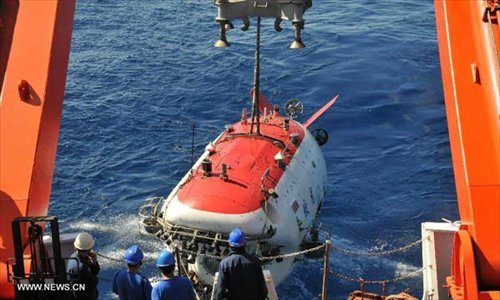 China's manned submersible Jiaolong is hoisted by its support ship Xiangyanghong 09 for a deep-sea dive into the south China sea, July 3, 2013. The Jiaolong manned submersible on Wednesday carried out a scientific dive to conduct geological sampling on a complex terrain. Photo: Xinhua