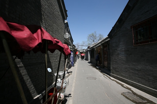 The tricycle is the symbol of Hutongs(Photo: CRIENGLISH.com/ Wang Zhi)A Hutong is a traditional alley, characteristic of an old Beijing city. A total of 7000 Hutongs have been built throughout the capital in straight lines under strict construction guildlines. The longest Hutong starts from the Beijing Legation Quarter, Dong Jiao Min Xiang,to the Xijiao Min Xiang, and has a total length of 6.5 kilometers, while the shortest Hutong is One-inch Street at only several meters' long. The narrowest Hutong is only about 0.7 meters wide. Therefore, people carrying even a little bit of extra weight have to hold their breath to pass through it. Formed during the Yuan, Ming and Qing, dynasties thousands of Hutongs surround the supreme Imperial Palace from all directions. They are woven into the fabric of people's daily lives.