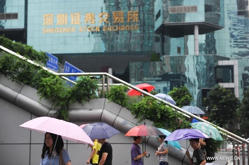 Pedestrians walk amid rain in Shenzhen, south China's Guangdong Province, May 26, 2013. Torrential rain hit most parts of Guangdong Province from Saturday to Sunday. (Xinhua/Mao Siqian)  