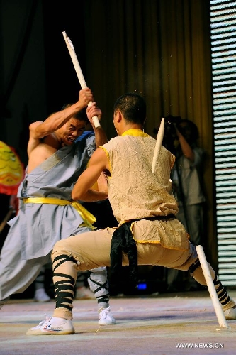 Performers of the Yandong Shaolin Kungfu troupe break a stick by hitting physical parts during a performance held at the Worker's Cultural Palace, Taiyuan, capital of north China's Shanxi Province, July 6, 2013. The martial art troupe have their performers trained in the renowned Shaolin Temple, and staged performances worldwide in the hope of promoting Shaolin-style martial arts and Chinese culture. (Xinhua/Fan Minda)  