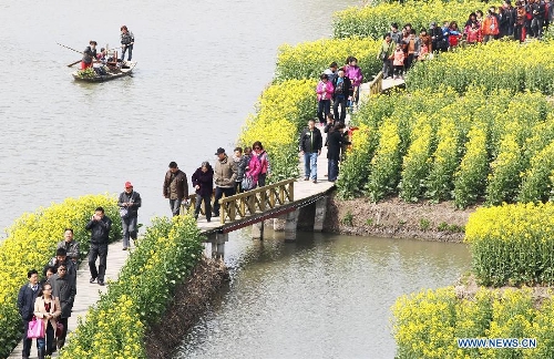 Tourists enjoy cole flowers at the Qiandao Cole Flower Scenic Spot in Ganggu Township of Xinghua City, east China's Jiangsu Province, April 3, 2013. (Xinhua/Zhou Haijun) 