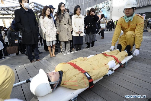 Workers show medical emergency measures during a drill in Tokyo, capital of Japan, on March 11, 2013. A drill to take precautions against natural calamities including medical emergency and fire fighting drills was held here to mark the two year anniversary of the March 11 earthquke and ensuing tsunami that left more than 19,000 people dead or missing and triggered a nuclear accident the world had never seen since 1986. (Xinhua/Kenichiro Seki) 