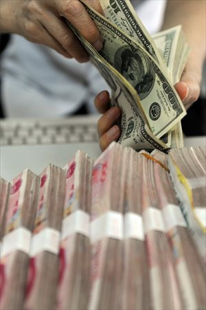 A bank teller counts bills at an Agricultural Bank of China branch in Qionghai, Hainan Province, Monday. The central parity rate of the yuan against the US dollar strengthened 92 basis points to 6.2920 Monday, according to the China Foreign Exchange Trading System. Photo: CFP