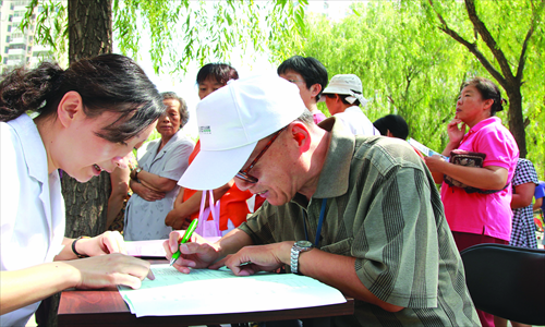 A doctor encourages a resident of a local community to register at a nearby clinic. Photo: CFP