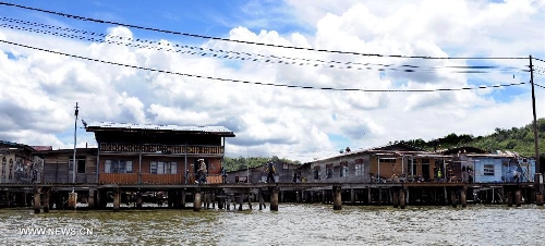 Pedestrians walks on a wooden walkway in the Water Village in Brunei's capital city Bandar Seri Begawan, April 24, 2013. Dubbed as Venice of the East and situated along the Brunei River, Kampong Ayer is the world's largest water village, sheltering about 30,000 inhabitants. It covers an area of 2.6 square kilo-meters and consists of 10 villages whose building are constructed on the Brunei River. (Xinhua/He Jingjia) 