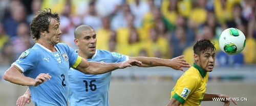 Brazil's Neymar (R) vies for the ball with Diego Lugano (L) of Uruguay, during the FIFA's Confederations Cup Brazil 2013 semifinal match, held at Mineirao Stadium, in Belo Horizonte, Minas Gerais state, Brazil, on June 26, 2013. (Xinhua/Liao Yujie)