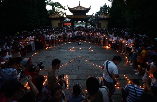  People light candles during a commemorating ceremony to mourn the death of Wang Jialin and Ye Mengyuan, two young girls killed in a crash landing of an Asiana Airlines Boeing 777 at San Francisco airport, in Jiangshan City, east China's Zhejiang Province, July 8, 2013. Local residents gathered at Xujiang Park in Jiangshan to show their grief to the 17-year-old Wang and 16-year-old Ye, who were students from Jiangshan High School. (Xinhua/Han Chuanhao)