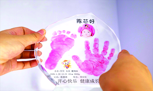 A crystal memento of a baby's hand and footprint, along with her picture, name and birth date. 
Photos: IC