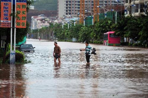 Two citizens wade through a waterlogged road in Fangchenggang city, South China's Guangxi Zhuang Autonomous Region, August 18, 2012. Typhoon Kai-Tak has affected about 1.26 million people and 134,470 hectares of farmlands in Guangxi till 4:30 pm Saturday. Local flood control authority initiated a Level IV emergency response to cope with the possible flooding. Photo: Xinhua