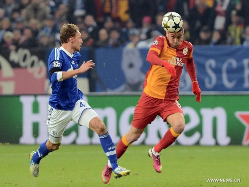  Benedikt Hoewedes (L) of FC Schalke 04 vies with Burak Yilmaz of Galatasaray during the UEFA Champions League eighth-final match at Veltins Arena in Gelsenkirchen, west Germany, March 12, 2013. Galatasaray won 3-2 and entered the quarterfinal. (Xinhua/Ma Ning) 