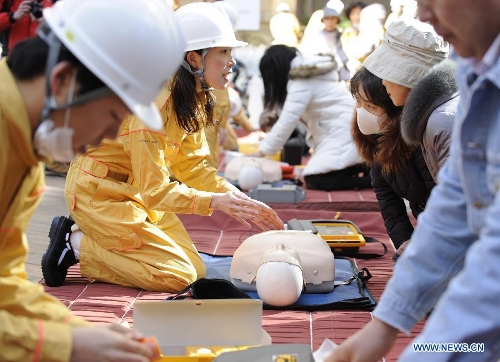 Workers show medical emergency measures during a drill in Tokyo, capital of Japan, on March 11, 2013. A drill to take precautions against natural calamities including medical emergency and fire fighting drills was held here to mark the two year anniversary of the March 11 earthquke and ensuing tsunami that left more than 19,000 people dead or missing and triggered a nuclear accident the world had never seen since 1986. (Xinhua/Kenichiro Seki)  