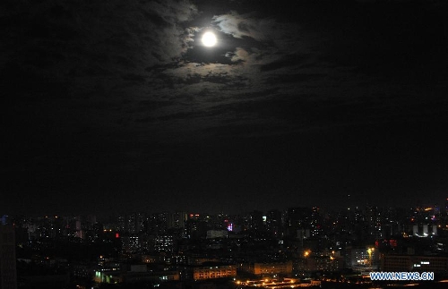 A full moon is seen surrounded by cloud in Haikou, capital of south China's Hainan Province, June 23, 2013. The moon looks 14 percent larger and 30 percent brighter than usual on Sunday. The scientific term for the phenomenon is 