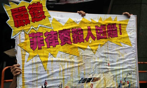 The protestors hold a banner, which says “The Philippine government should punish their coast guard.” Photo:China News Service