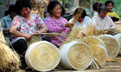 Farmers weave cat and dog furniture from wheat stalks in Tancheng county, East China's Shandong Province on Wednesday. Around the wheat harvest, local farmers use wheat byproduct stalks to make handicrafts for export. The county produces one million pieces of handicraft annually. Photo: IC 