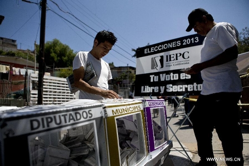 Citizens cast their votes during the election day in the Lomas Taurinas suburb in Tijuana, Baja California, Mexico, on July 7, 2013. On Sunday, elections took place in Mexico's 14 states, where state legislatures and mayorships would be renewed. (Xinhua/Guillermo Arias) 