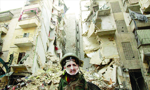 A dummy dressed up in army fatigues and a mask depicting Syrian President Bashar al-Assad is erected in the Salaheddine neighborhood of Aleppo, the scene of heavy fighting on Saturday.  Photo: AFP