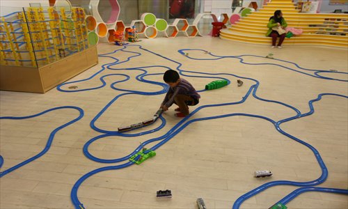 A boy builds railways and trains at the transportation section at Omocha Toys Kingdom. Photo: Cai Xianmin/GT