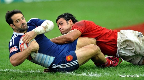 Julien Candelon (L) of France scores during a match against Argentina at the Hong Kong Sevens rugby tournament in south China's Hong Kong, March 24, 2013. France won the match 19-14 to win the 13th place. (Xinhua/Lo Ping Fai) 