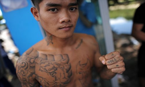 A Thai prisoner strikes a pose at the end of a release ceremony at the Klong Prem prison in Bangkok on Thursday. Some 30,000 prisoners were scheduled to be released from prisons nationwide on royal clemency to celebrate this year's birthdays of Crown Prince Maha Vajiralongkorn and Queen Sirikit. Those entitled to receive the royal pardon are below 20 or above 60 in age, sick or disabled, and serving a sentence for a minor case. Photo: AFP    