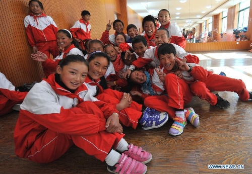 Pupils of the Tibetan ethnic group pose for photos at No. 1 Primary School of Deqin County in Diqing Tibetan Autonomous Prefecture, southwest China's Yunnan Province, March 12, 2013. A total of 1,260 pupils, most of whom are of the Tibetan ethnic group, study at this school, which was founded in September 2012. Pupils here are offered free meals and lodging. (Xinhua/Lin Yiguang)  