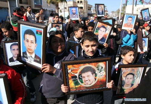 Kids hold their dead relatives' photos during a celebration for the second anniversary of the uprising that toppled the regime of strongman Muammar Gaddafi in the Tajoura area in the Libyan capital Tripoli, on Feb. 17, 2013. (Xinhua/Hamza Turkia) 