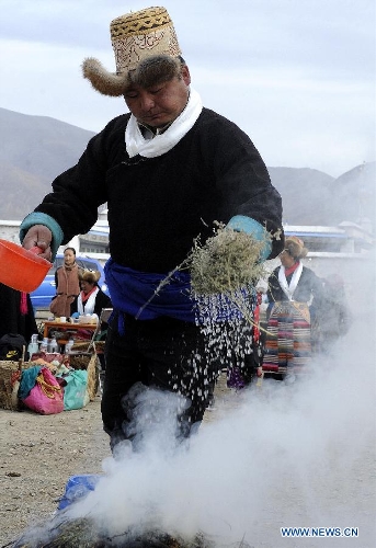 A farmer of the Tibetan ethnic group burns incense to pray for a good harvest during a ceremony to celebrate the starting of spring plowing at Deqing Village of Dazi County, southwest China's Tibet Autonomous Region, March 16, 2013. (Xinhua/Chogo) 